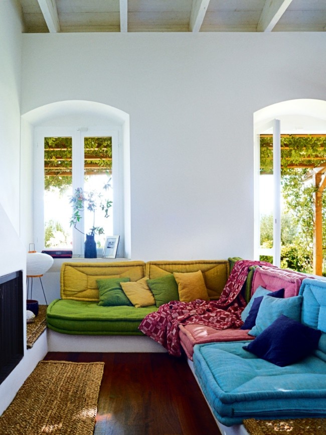 The living room in the Stockdale-Newson’s Ithaca cottage features brightly coloured handcrafted ‘Taki’ lounge cushions by Greek furniture design company Coco-Mat, and pieces gathered from the couple’s travels.