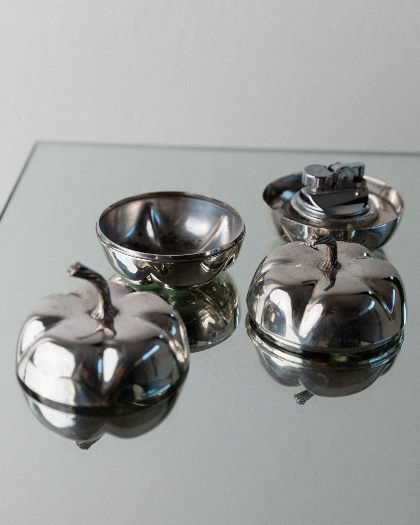 Silver-plated vintage Christian Dior Pumpkin set lighter &amp; ashtray or bowl, 70s

This silver-plated vintage Christian Dior Pumpkin set from the 1970s includes two lidded bowls in a pumpkin design, one of which has a removable integrated lighter.